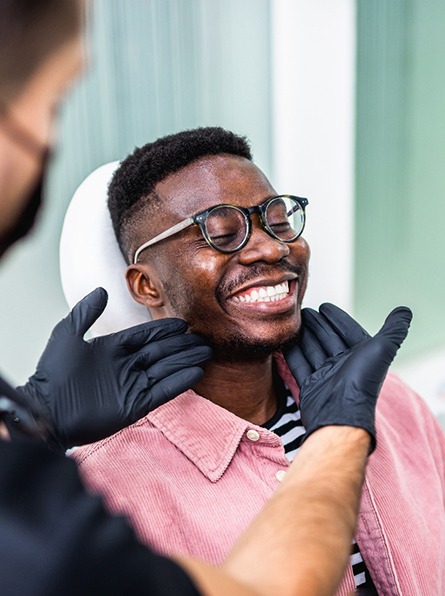 Dentist looking at smiling patient's teeth